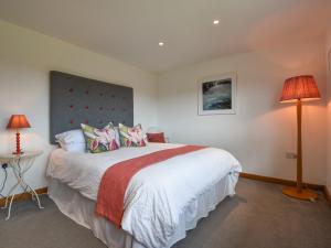 a bedroom with a large bed and a lamp at Orchard View in South Pool