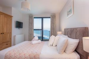 a bedroom with a bed with a view of the ocean at Rock Pool in Mortehoe