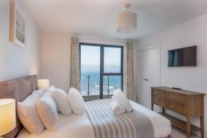a bedroom with a bed with a view of the ocean at Rock Pool in Mortehoe