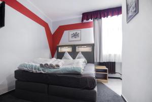 1 dormitorio con 1 cama con rayas rojas en Pension Ayky en Jablonec nad Nisou