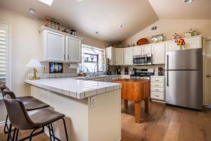 a kitchen with white cabinets and a stainless steel refrigerator at Bay View Ridge Holiday Home Private Pool Hot Tub between Santa Cruz and Monterey in Watsonville