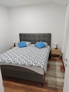 ein Schlafzimmer mit einem Bett mit blauen Kissen darauf in der Unterkunft Kuca Imotski in Imotski