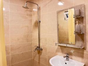 a bathroom with a sink and a shower with a mirror at Nuray's House in Sheki