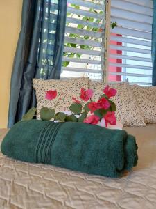 a green blanket and flowers on a bed at Villa Stellia @drvacationsrental in La Laguna