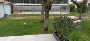 un patio con un invernadero y un árbol en La Mikisa, en Marsas