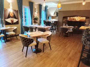 a restaurant with tables and chairs in a room at Chateau De Montreuil in Montreuil-sur-Mer