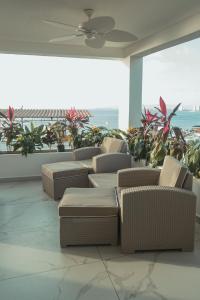 Zimmer mit Stühlen, Tischen und einem Deckenventilator in der Unterkunft Casa Nawalli Puerto Vallarta Boutique Hotel - Adults Only in Puerto Vallarta