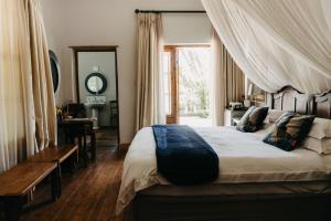 a bedroom with a large bed with a canopy at The Bethesda in Nieu-Bethesda