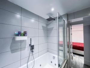 een badkamer met een douche en een bad bij Ensuite Room with Jacuzzi in Londen