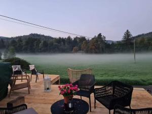 a patio with chairs and a table with a foggy field at Wellness-Beskydy in Prostřední Bečva