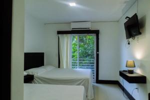 a hotel room with two beds and a window at HOTEL ARRECIFE in Roatán