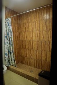 a bathroom with a shower curtain and a toilet at HOTEL ARRECIFE in Roatán