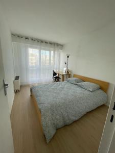 - une chambre avec un grand lit et une fenêtre dans l'établissement Bel appartement tout confort aux Portes de Paris, à Cergy