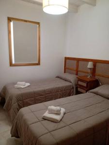 Habitación con 2 camas y toallas. en La Juliana en Villa La Angostura