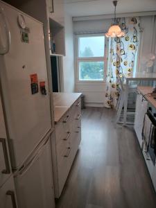 a kitchen with a white refrigerator and a window at Seaview apartment central location Helsinki in Helsinki