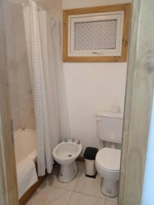 a bathroom with a toilet and a sink and a tub at La Juliana in Villa La Angostura