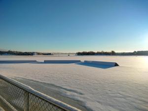 a hockey field with a fence and water at Seaview apartment central location Helsinki in Helsinki +6 photos