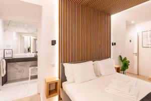 1 Schlafzimmer mit einem weißen Bett und einem Badezimmer in der Unterkunft Charming Loft in Bairro Alto - JJ Apartment`s in Lissabon