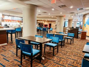 a dining room with tables and blue chairs at Courtyard by Marriott Alexandria Pentagon South in Alexandria
