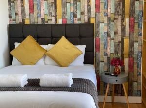 um quarto com uma cama grande e almofadas amarelas em Portobello Road Artistic Studios 'BUDGET' em Londres