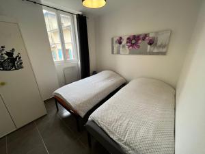 ラ・トゥール・デュ・パンにあるAppartement la Gareの窓のある部屋にツインベッドが2台