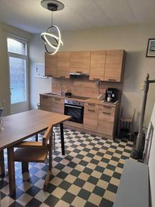 uma cozinha com uma mesa e um piso em xadrez em La pleine lune em Chimay