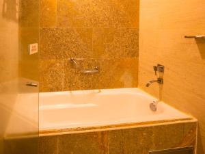 uma banheira na casa de banho com uma parede de vidro em Las Americas Torre Del Mar em Cartagena das Índias