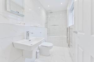 ein weißes Bad mit einem WC und einem Waschbecken in der Unterkunft Spacious 1 Bedroom Apartment in Cheltenham Centre 