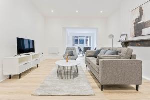 a living room with a couch and a tv at Spacious 1 Bedroom Apartment in Cheltenham Centre 