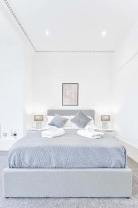 ein weißes Schlafzimmer mit einem großen Bett mit zwei Kissen in der Unterkunft Spacious 1 Bedroom Apartment in Cheltenham Centre 