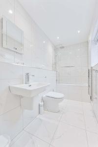 a white bathroom with a sink and a toilet at Spacious 1 Bedroom Apartment in Cheltenham Centre 