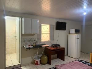 a kitchen with a refrigerator and a table in it at 203 verão kit exclusiva in Brasilia