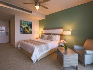 een slaapkamer met een bed, een bank en een stoel bij Las Americas Torre Del Mar in Cartagena