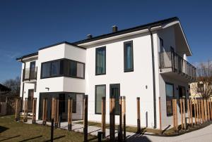 a white house with black windows and a fence at Villa Boris in Starše