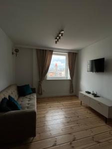 sala de estar con sofá y ventana en Brickller Apartments by Letrent, en Żyrardów