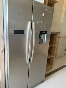 a stainless steel refrigerator with two doors in a kitchen at Slipway Seaview in Dar es Salaam