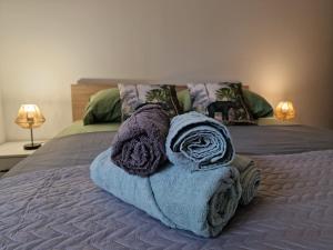 a bed with a pile of towels on it at App Moonlight, Omišalj, Krk in Omišalj