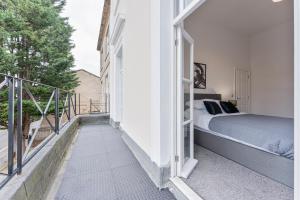 a bedroom with a bed on a balcony at Modern 2 Bedroom Apartment in Central Cheltenham in Cheltenham