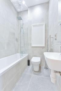a white bathroom with a toilet and a sink at Stylish 2 Bedroom Apartment in Central Cheltenham in Cheltenham