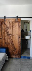 uma porta deslizante de celeiro num quarto com um lavatório em Il Faro La Ciaccia em Codaruina