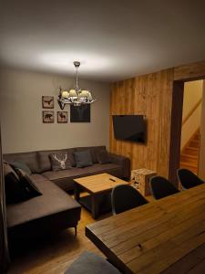 a living room with a couch and a table at Naturepark Resort in Harrachov