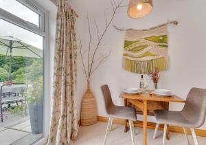 a dining room with a table and chairs and a window at Nyth Bryn Haul in Llanidloes