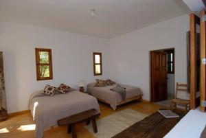 twee bedden in een kamer met witte muren bij La Ventana, La Paz Rancho Ancon Mountain and Sea Desert Oasis in La Ventana