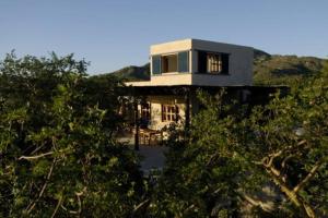 een huis bovenop een heuvel met bomen bij La Ventana, La Paz Rancho Ancon Mountain and Sea Desert Oasis in La Ventana