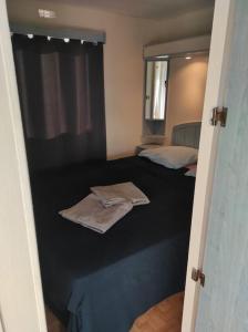 a bedroom with two beds with towels on the floor at Mobil-home dans un beau cadre à 15 km des plages. in Lunel