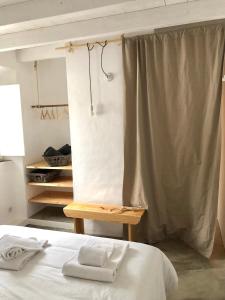 a bedroom with a bed with a table and a curtain at Casas de Seixe in Baiona