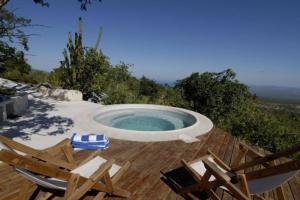 een zwembad met 2 stoelen en een tafel bij La Ventana, La Paz Rancho Ancon Mountain and Sea Desert Oasis in La Ventana