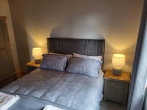 a bedroom with a large bed with two lamps on tables at White O'Morn Cabin in Newry