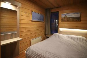 sypialnia z łóżkiem w pokoju z drewnianymi ścianami w obiekcie Tunturipöllö 2 w mieście Ruka