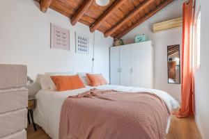 1 dormitorio con 1 cama grande con almohadas de color naranja en Maravilloso estudio en Chamberi. Metro Quevedo en Madrid